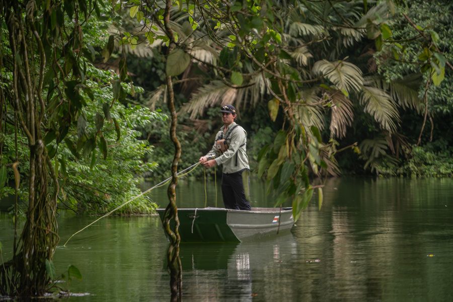 Pescador con mosca rodeado de selva en la Laguna Tabacón